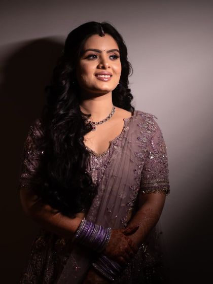 Glowing with happiness, this bride-to-be is the picture of elegance and joy. The soft lighting highlights her radiant smile and beautiful lavender lehenga.