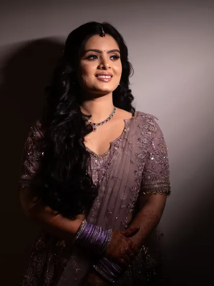 Glowing with happiness, this bride-to-be is the picture of elegance and joy. The soft lighting highlights her radiant smile and beautiful lavender lehenga.
