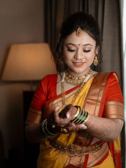 A beautiful close-up of the bride admiring her green glass bangles, a significant part of the Maharashtrian bridal look.