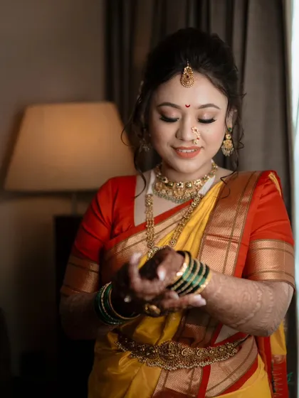 A beautiful close-up of the bride admiring her green glass bangles, a significant part of the Maharashtrian bridal look.