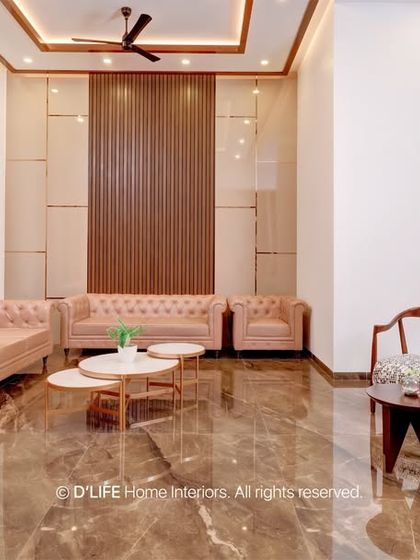 A beautiful living room with plush, light pink tufted sofas and a wood-paneled accent wall. The design is soft, luxurious, and inviting.