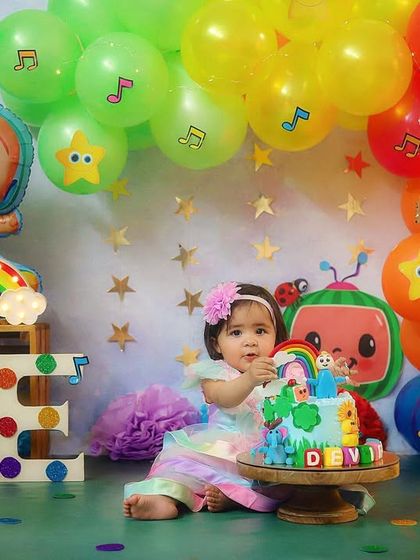 For the little one who loves Cocomelon! This colourful first birthday setup is inspired by the popular show, complete with character balloons and a rainbow cake.