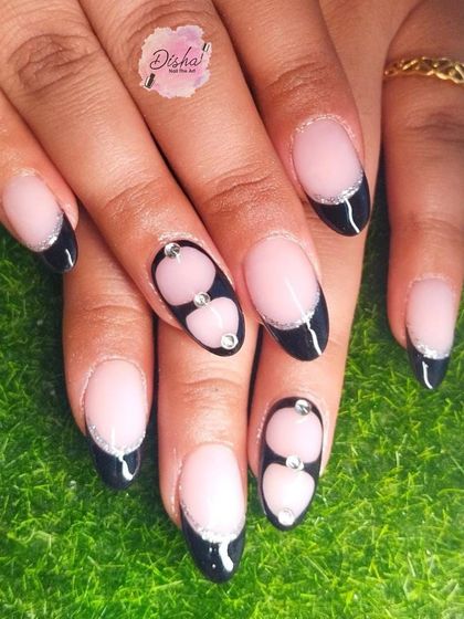 Black French tips with a twist. This design adds silver glitter and cute 3D hearts for a look that's both edgy and sweet.