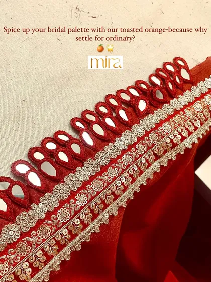 A detailed view of the mirror work and intricate embroidery on my special 'toasted orange' fabric. This unique color and craftsmanship adds a vibrant, festive touch to any bridal outfit.