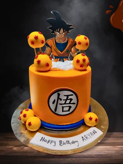 A powerful cake for a Dragon Ball Z fan. This orange cake is decorated with the iconic Dragon Balls and features a topper of Goku, ready for action.