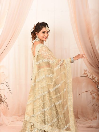A joyful and radiant studio portrait. Her smile and pose, combined with the elegant lehenga, create a stunning image.