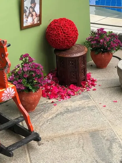 More details from the 1990s-themed naming ceremony. A traditional wooden rocking horse and a stone grinder are placed as decor elements, evoking a sense of nostalgia and childhood.