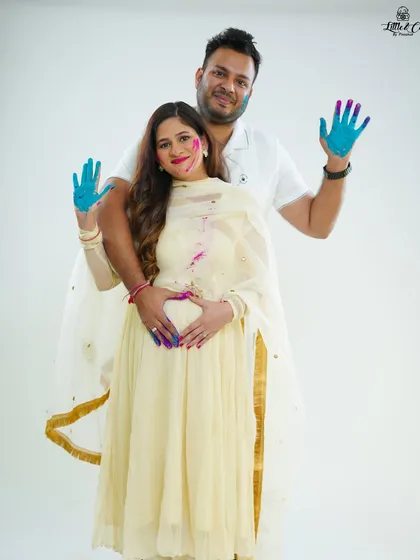 The couple proudly displays their colorful hands while the mother-to-be forms a heart over her baby bump. It's a creative and joyful way to celebrate their growing family.