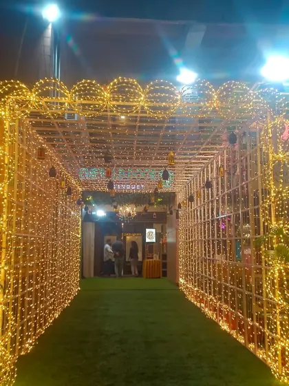 Here’s how we use lighting to create magic. This stunning entrance tunnel, built with a bamboo frame and wrapped entirely in fairy lights, provides a warm, glittering welcome for guests and a perfect photo opportunity.