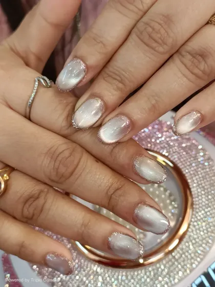 Another angle of the white cat-eye nails with glitter outlines. This view shows how the light plays on the magnetic polish, creating a beautiful, shifting dimension.