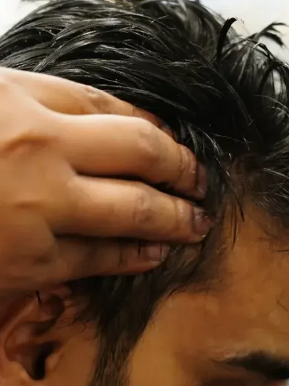 A little tender loving care goes a long way. This image captures a moment of pure relaxation during a head massage, designed to soothe and rejuvenate.