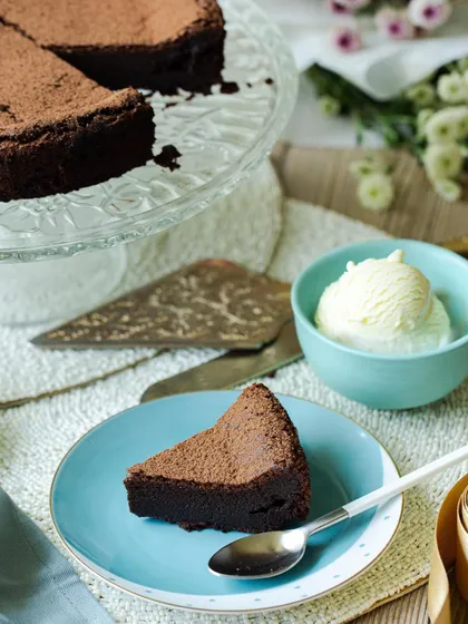 A slice of my flourless dark chocolate cake served with a scoop of vanilla ice cream. This gluten-free cake is rich, fudgy, and utterly satisfying.