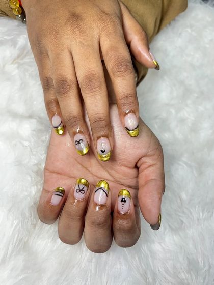 A full view of the hands with the gold chrome French manicure. This is a perfect example of how we can put a modern and artistic spin on a classic style.