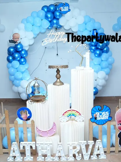 A simple Boss Baby ring decoration with light blue and white balloons. The character cutouts and props like the rainbow and moon add a playful element.