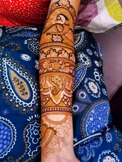 A single arm view of a beautiful design featuring peacocks and paisleys, showcasing the level of detail I put into every part of the mehendi.