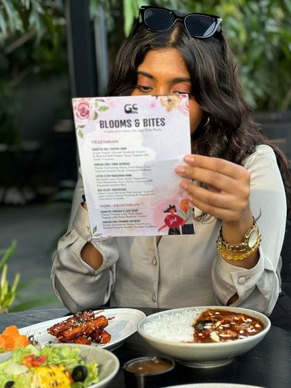 A guest peeking over our 'Blooms & Bites' menu. It's always fun to see the excitement of choosing from a menu specially curated for a fun gathering.