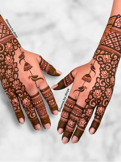 This intricate design combines lotus and rose florals with delicate jhumka and bird motifs. The detailed grid work on the cuff adds another layer of traditional beauty.