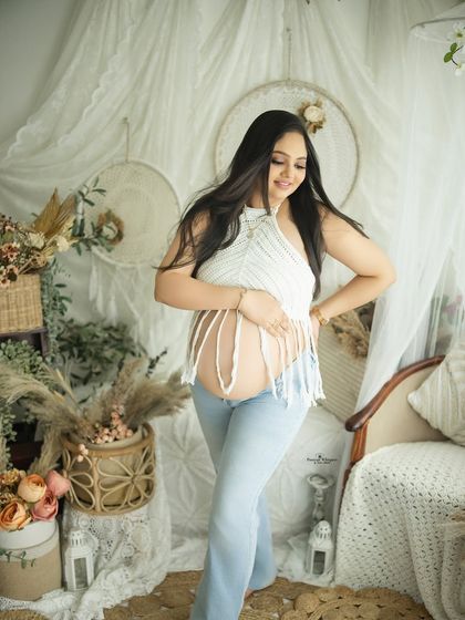 A beautiful solo portrait in a casual, boho-inspired outfit. The crochet top and jeans offer a stylish yet comfortable look for a maternity session.
