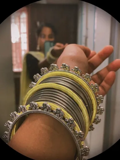A beautiful stack of yellow silk thread and oxidised silver bangles, featuring delicate elephant charms. This set was part of a complete yellow-themed look I created.