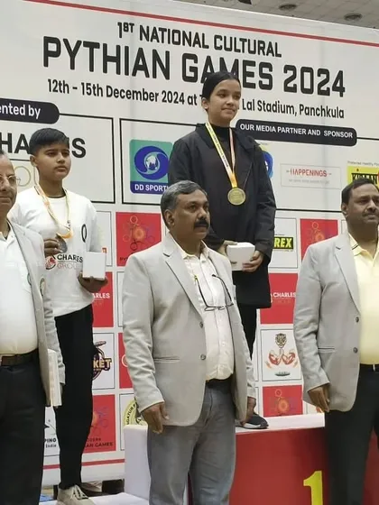 A student from my academy standing proudly on the winner's podium at the 1st National Cultural Pythian Games. A moment of great achievement.