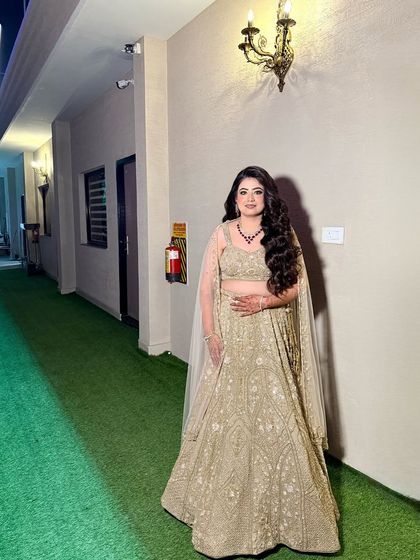 The full look for Bhoomika's engagement. The golden lehenga is paired with a warm, smokey eye and voluminous hair.