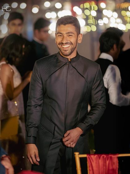 A candid shot showing the achkan in motion. It’s designed to be comfortable while maintaining its powerful, tailored shape throughout the celebration.