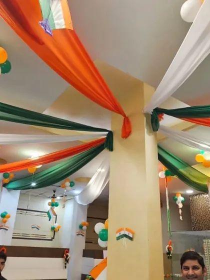 Ceiling decorations using long swathes of saffron, white, and green fabric can completely change an office environment. This creates an immersive patriotic theme for employees.