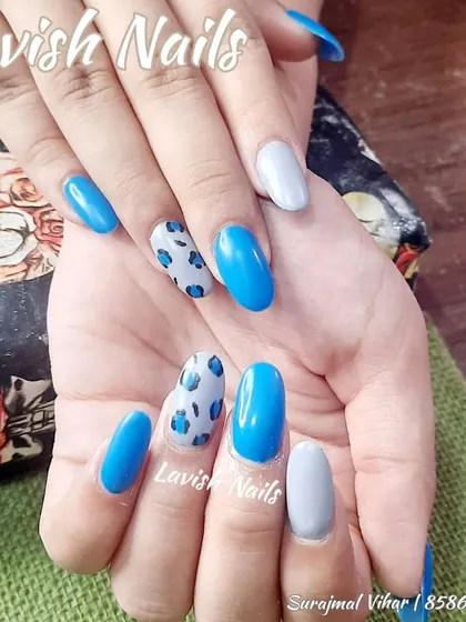 A fun and trendy set combining bright blue, grey, and a playful blue leopard print accent nail.