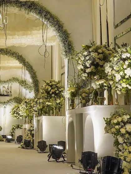 The enchanted forest theme continued with grand archways and massive arrangements of white flowers and baby's breath, creating a sense of scale and wonder.