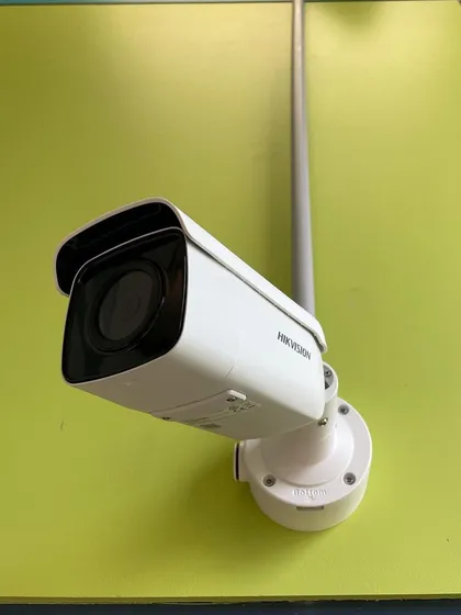 A single Hikvision camera installed with a pole mount against a brightly colored wall. We can install systems on any surface to achieve the best possible surveillance angle.