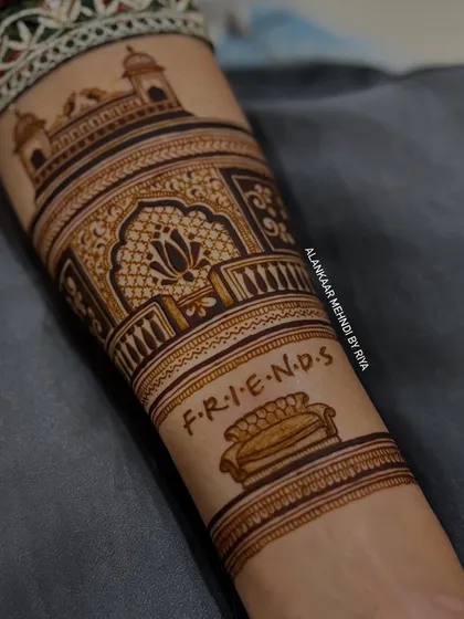 A close-up of the forearm, showing the iconic couch from the TV show 'FRIENDS' as part of a personalized bridal design.