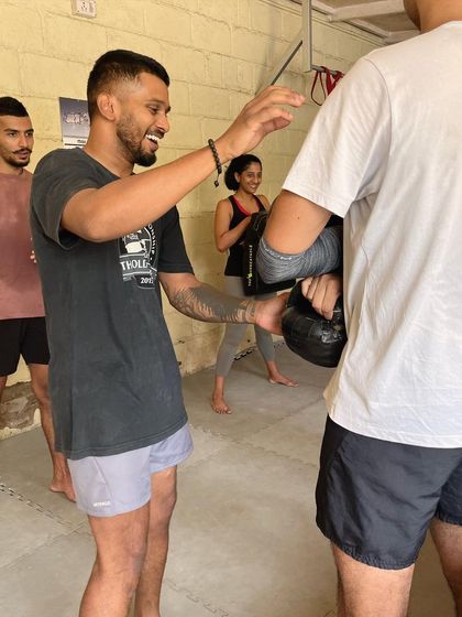 A coach demonstrating a technique with a kettlebell.