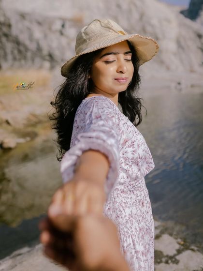 A classic "follow me to" shot, with the bride-to-be leading the way towards a beautiful lake surrounded by rock formations.