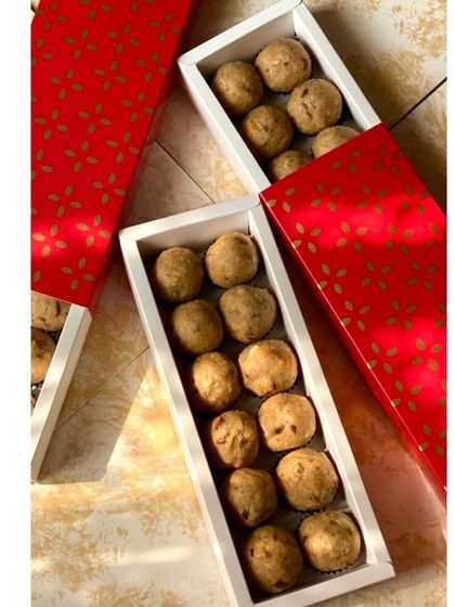 Our Atta Panjiri laddoos packed in elegant red and white drawer-style boxes. The packaging is designed to be both beautiful and sturdy for gifting.