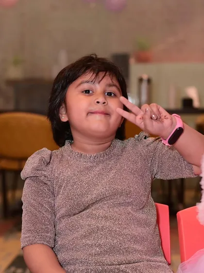 A young guest giving a peace sign. The kids always feel comfortable and happy in our fun-filled space.