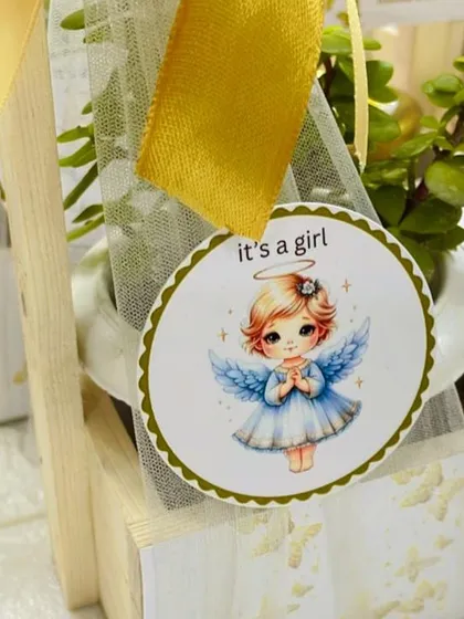 A close-up of the angelic "it's a girl" tag, showcasing the delicate artwork and high-quality printing I use for my personalized favors.