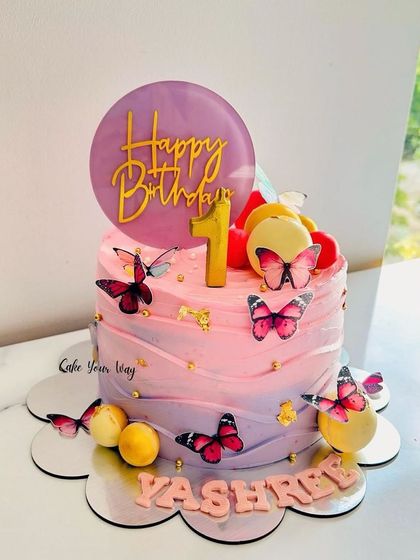 A flutter of sweetness in every slice. This pink and purple ombre cake is adorned with butterflies for a magical first birthday.