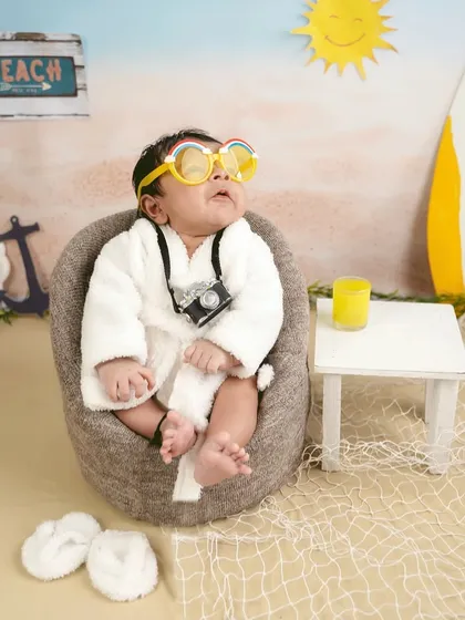 Soaking up the sun. The colorful sunglasses add a playful and funny element to this beach-themed milestone shoot.