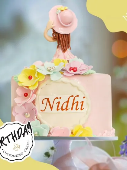 A pretty-in-pink floral cake for Nidhi's birthday. This design features a cascade of colorful sugar flowers and a stylish figurine topper.
