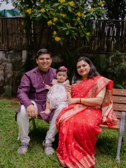 A beautiful family dressed in traditional and festive attire, posing on a park bench. We love incorporating special occasion outfits into our outdoor photoshoots.