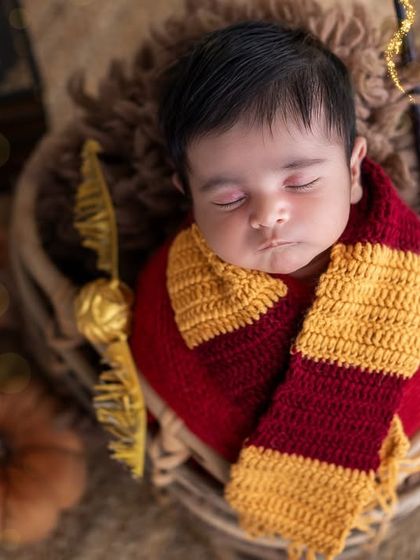 Our little wizard! I love when parents have a fun theme in mind, like this adorable Harry Potter newborn setup with a Gryffindor scarf and golden snitch.