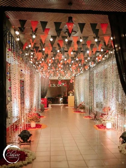Another perspective of the festive hallway, showing how black side drapes help to make the overhead lights and colorful pennants pop, creating a cozy yet exciting atmosphere.