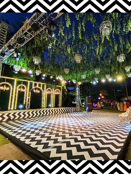For a modern and chic Sangeet, we designed this black and white chevron dance floor, complemented by a green ceiling installation and crystal chandeliers.