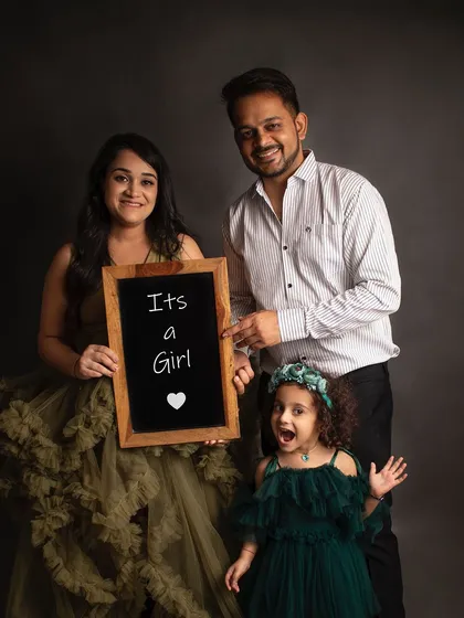 A fun family announcement photo. The older sister's excited expression is just priceless as they announce a baby girl is on the way.