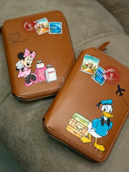 Getting ready for an adventure with these custom hand-painted passport covers, featuring Minnie and Donald Duck with their luggage.