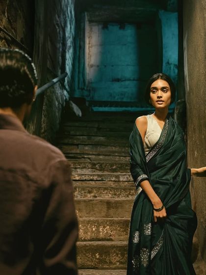 A tense, quiet moment from the 'Banaras Nocturne' campaign for Tilfi Banaras. The styling and location, a dark stone staircase, were chosen to create a sense of mystery and anticipation.