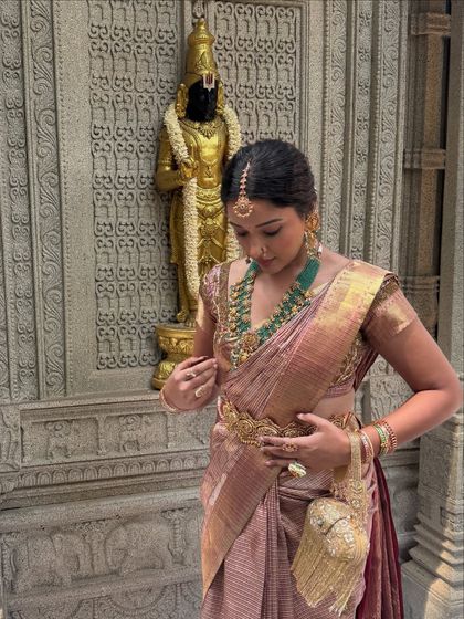 Adjusting the final details of the saree drape. It's these small touches that create a flawless final look.