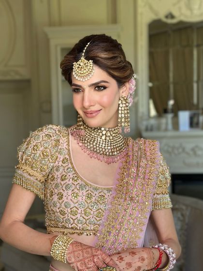 A portrait of bridal perfection. The soft, floral updo and statement jewelry come together to create a look that is both regal and romantic.