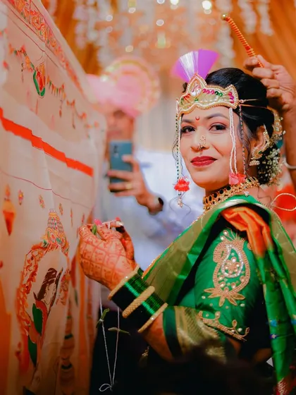 A beautiful shot of the Maharashtrian bride during the antarpat ceremony. She holds the thread, her eyes filled with emotion as she peeks from behind the ceremonial cloth.