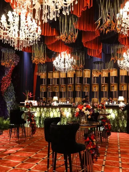 Another angle of the grand bar and high-top tables, showing the impressive scale of the floral wall and ceiling installation.
